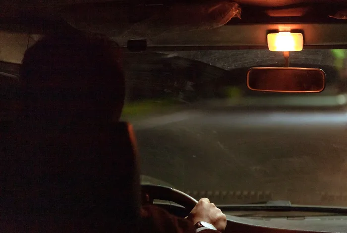 Gece arka koltuktan görülen özel bir aracın içi ve sürücü